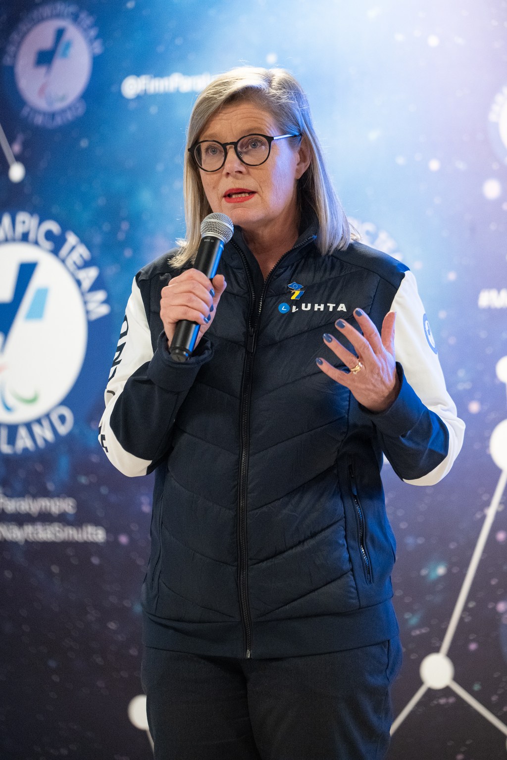 Sari Rautio puhumassa Pohjoisen tähdet -taustan edessä.